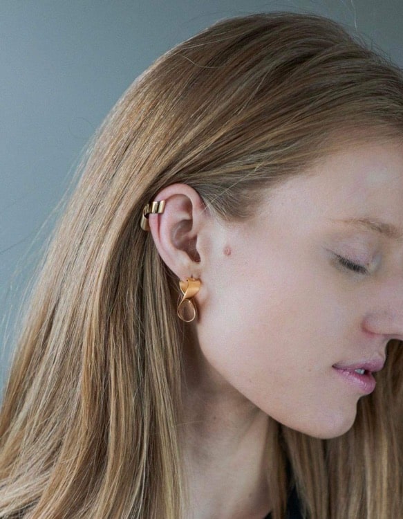 A blond woman wearing gold earrings